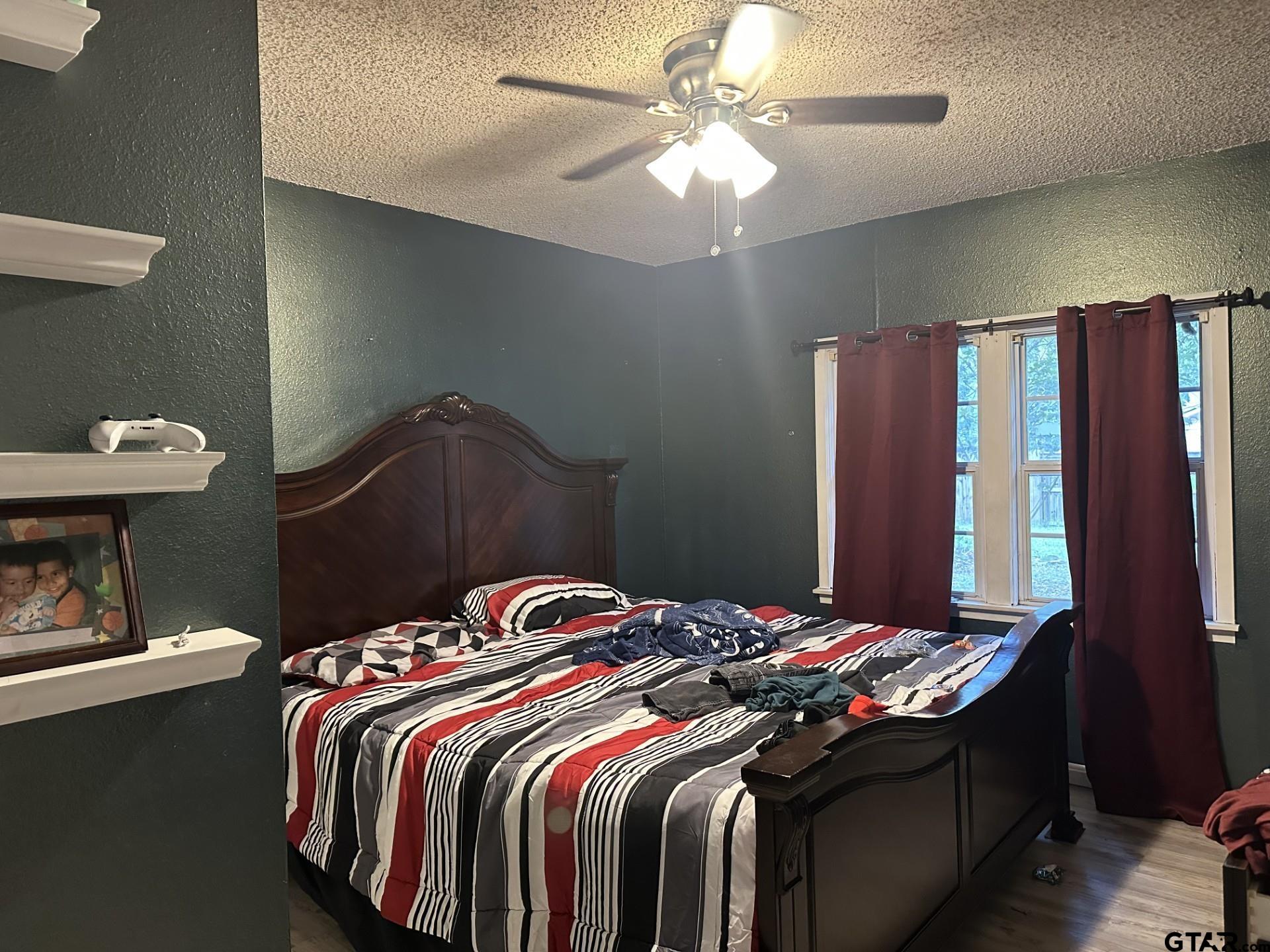 6287 County Road 334 Tyler, TX 75708 - Photo 6 of 8 a bedroom with a bed and a chandelier