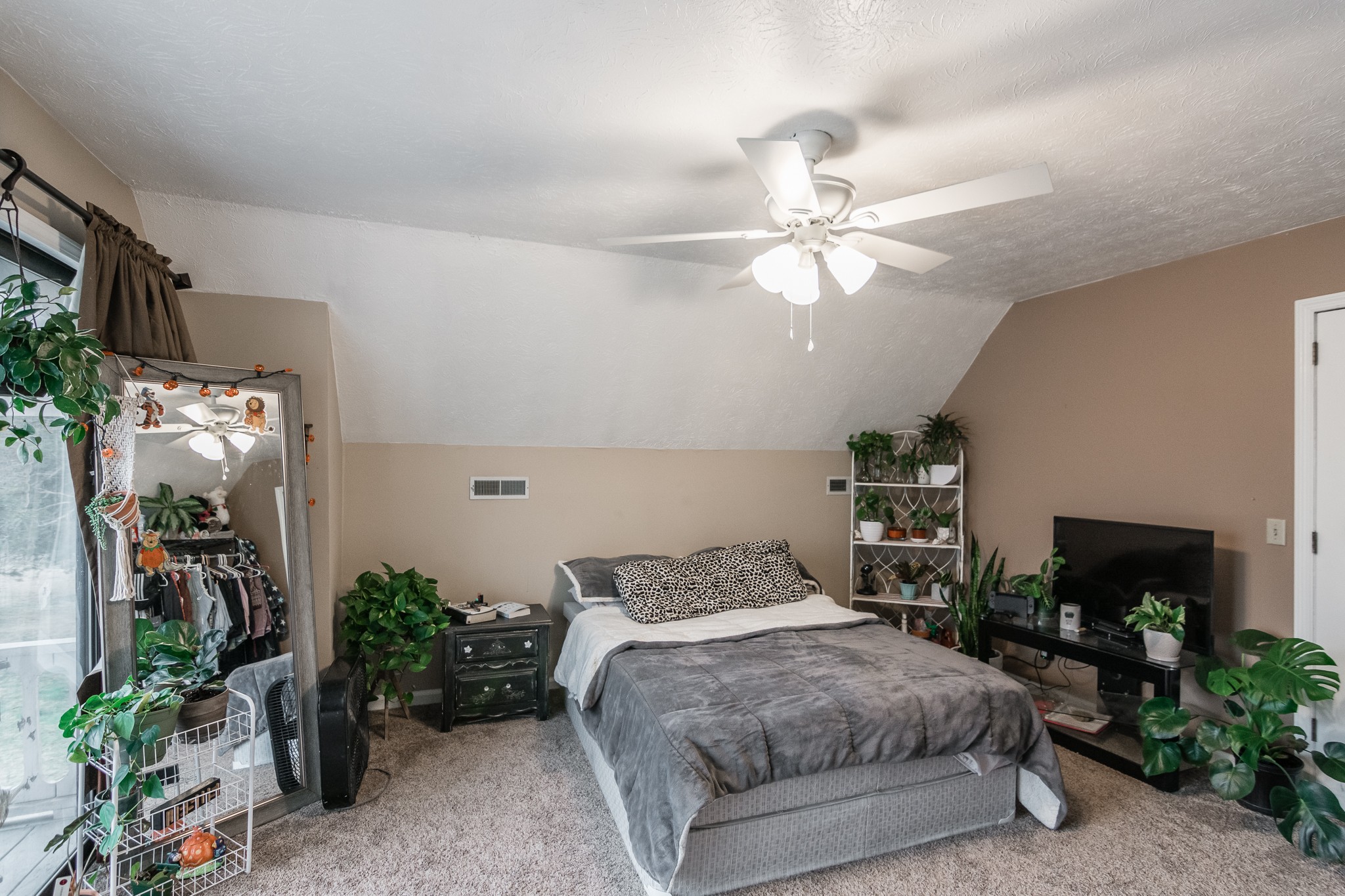 1005 Edgewater Circle Gallatin, TN 37066 - Photo 25 of 50 a bedroom with a bed potted plant on the dresser and a fireplace