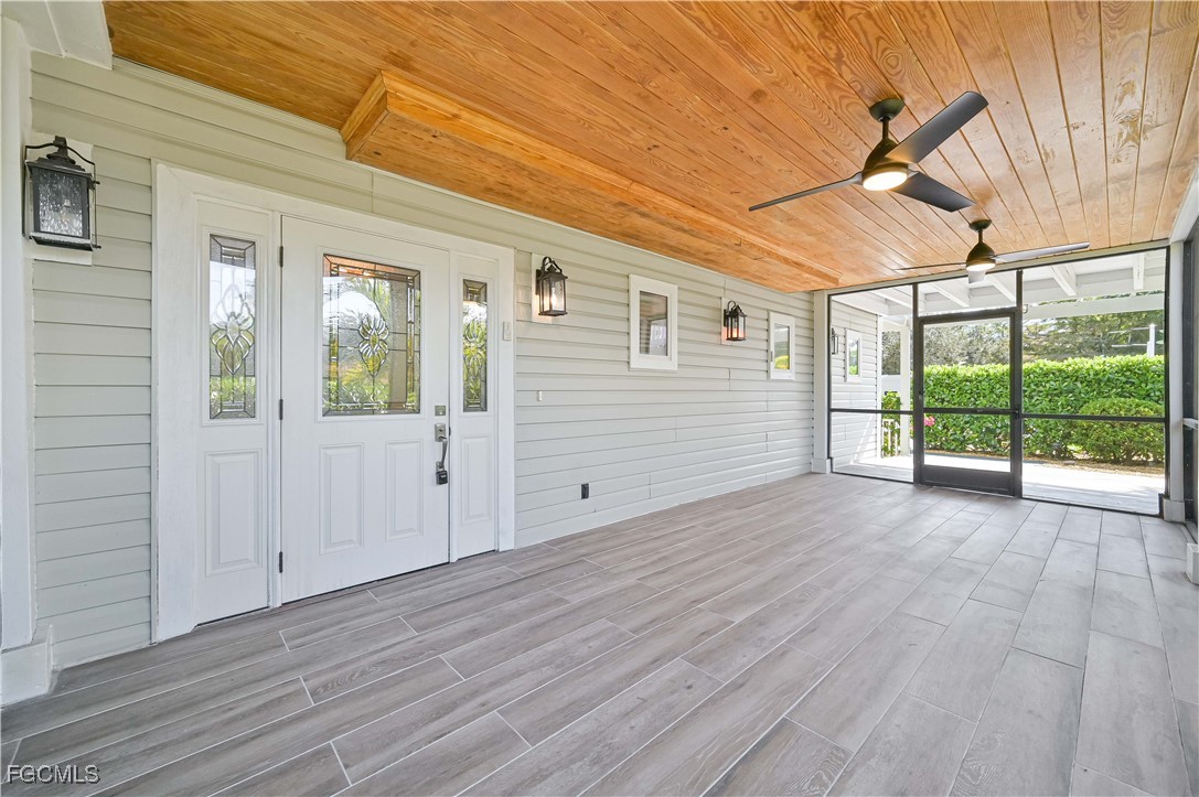 6941 Hunters Road Naples, FL 34109 - Photo 15 of 45 an empty room with wooden floor and windows