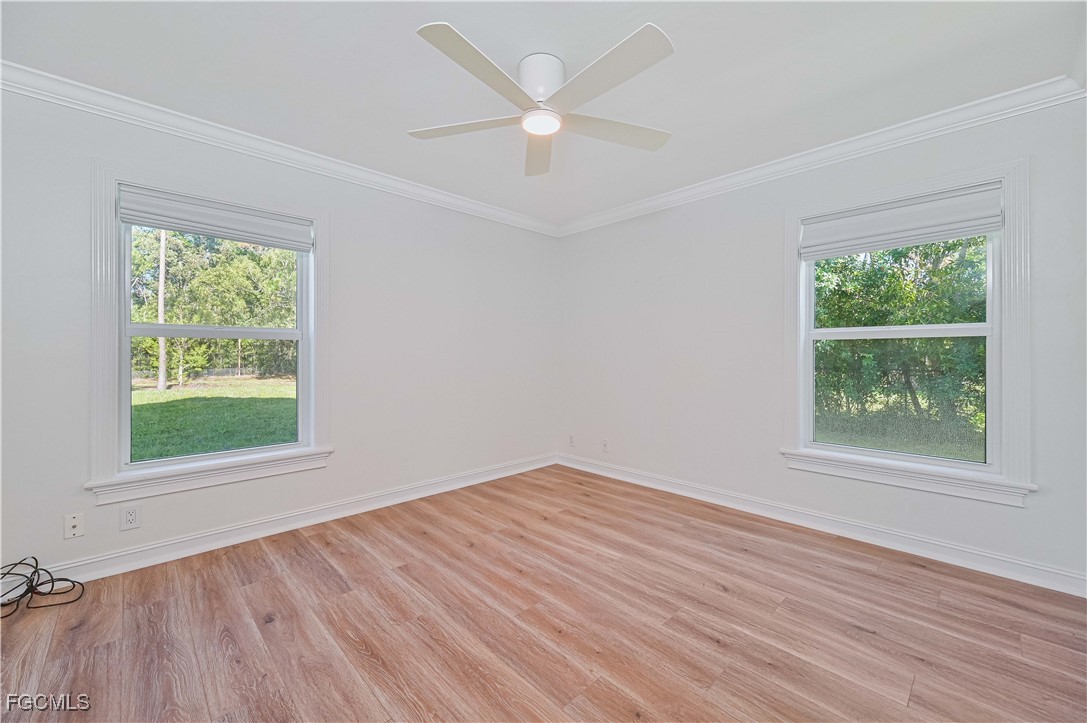 6941 Hunters Road Naples, FL 34109 - Photo 19 of 45 an empty room with wooden floor and windows