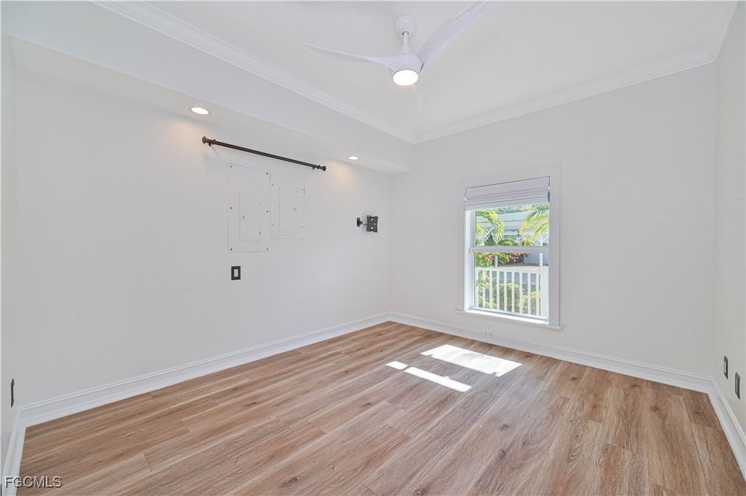 6941 Hunters Road Naples, FL 34109 - Photo 22 of 45 an empty room with wooden floor and windows