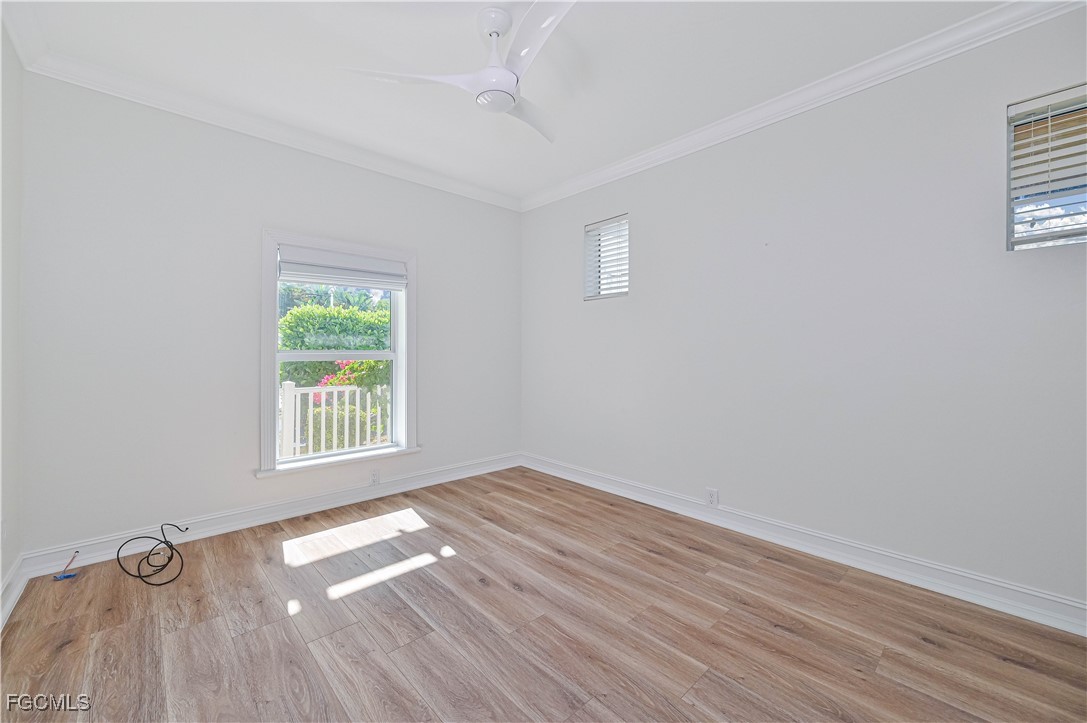 6941 Hunters Road Naples, FL 34109 - Photo 24 of 45 an empty room with wooden floor and windows