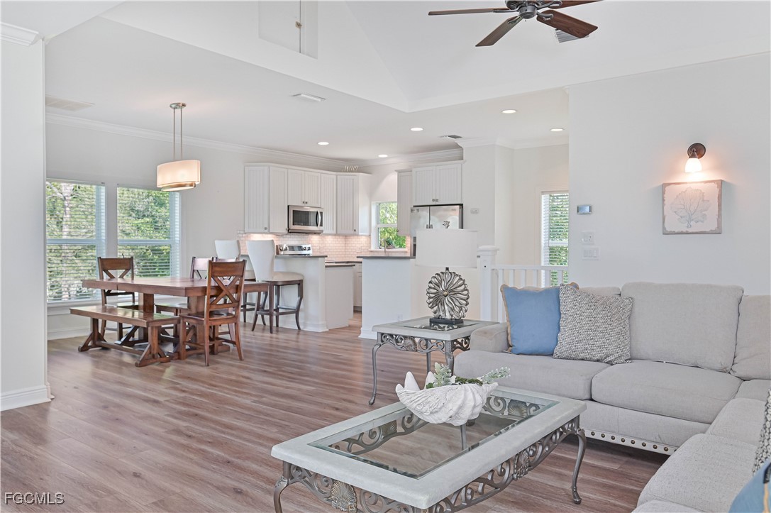 6941 Hunters Road Naples, FL 34109 - Photo 30 of 45 a living room with furniture a dining table and a chandelier