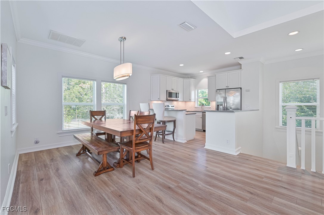 6941 Hunters Road Naples, FL 34109 - Photo 31 of 45 a view of a dining room with furniture window and wooden floor