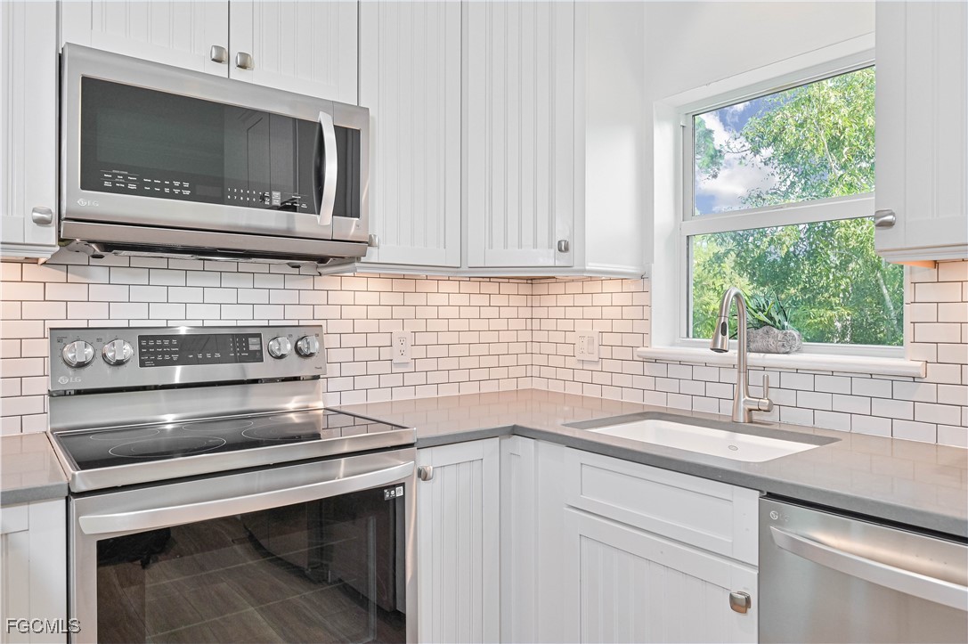 6941 Hunters Road Naples, FL 34109 - Photo 33 of 45 a kitchen with a sink microwave and window