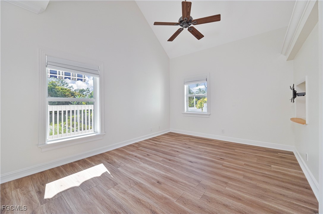 6941 Hunters Road Naples, FL 34109 - Photo 35 of 45 a view of an empty room with a window and wooden floor