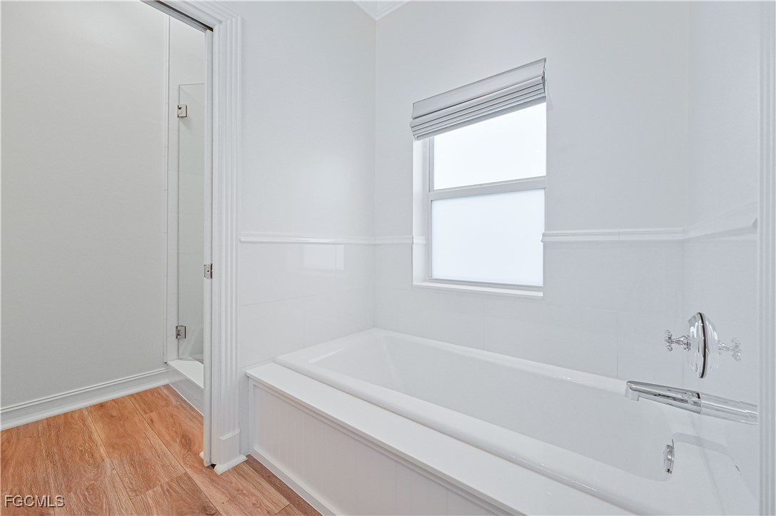 6941 Hunters Road Naples, FL 34109 - Photo 39 of 45 a bathroom with a bathtub and a window