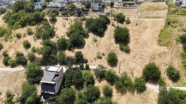 an aerial view of residential house with outdoor space and trees all around