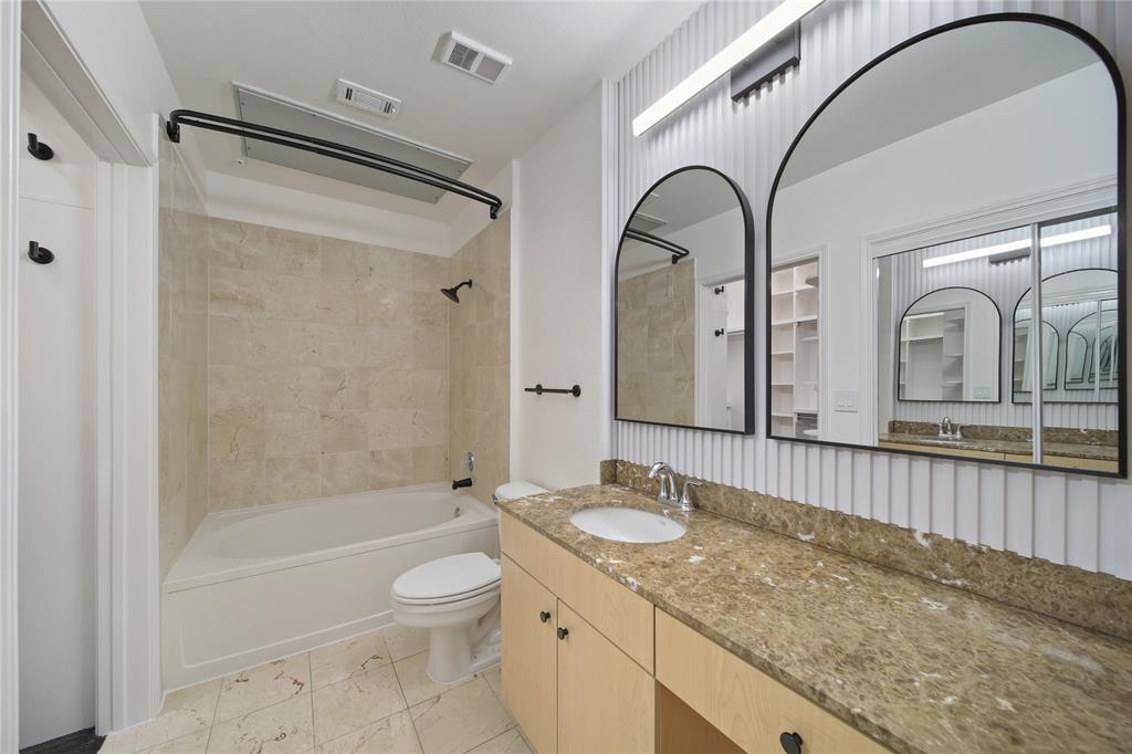 3225 Turtle Creek Boulevard, Unit 320 Dallas, TX 75219 - Photo 12 of 24 a bathroom with a granite countertop sink a toilet and a bathtub