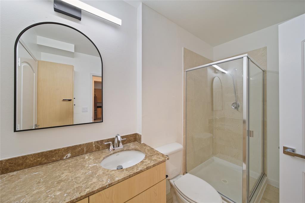 3225 Turtle Creek Boulevard, Unit 320 Dallas, TX 75219 - Photo 14 of 24 a bathroom with a granite countertop sink toilet and shower