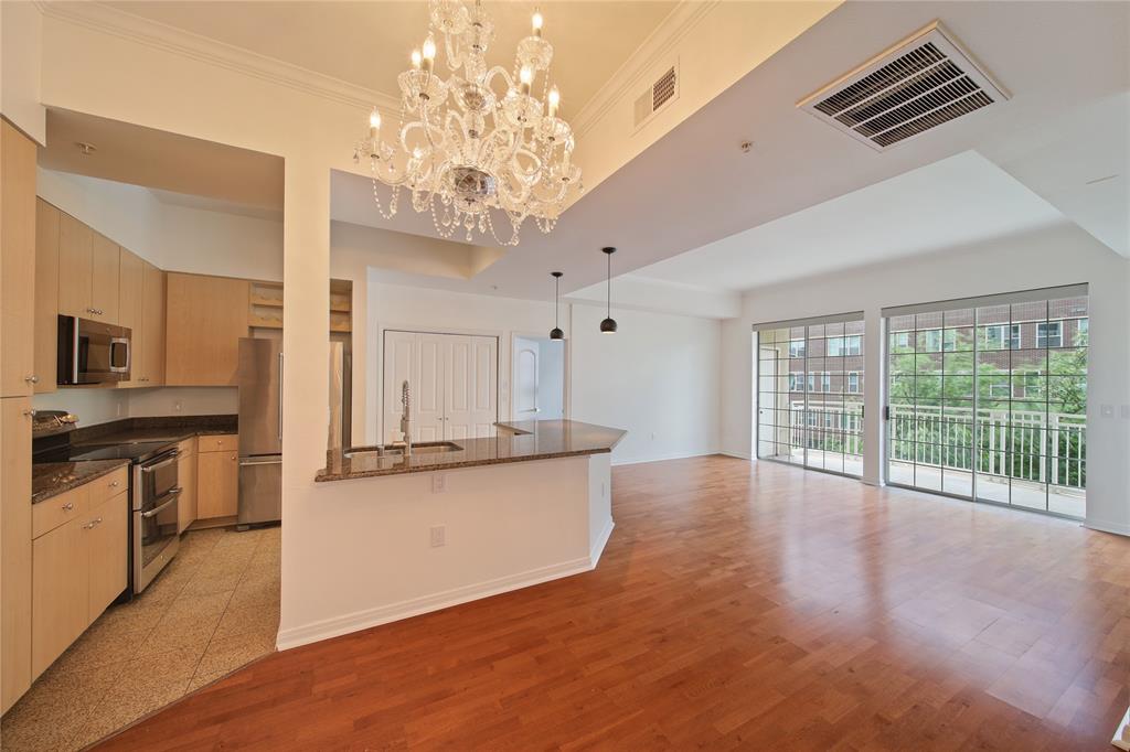 3225 Turtle Creek Boulevard, Unit 320 Dallas, TX 75219 - Photo 3 of 24 a large kitchen with kitchen island a large counter space a sink stainless steel appliances and cabinets