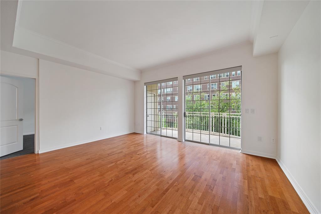 3225 Turtle Creek Boulevard, Unit 320 Dallas, TX 75219 - Photo 9 of 24 a view of an empty room with wooden floor and a window