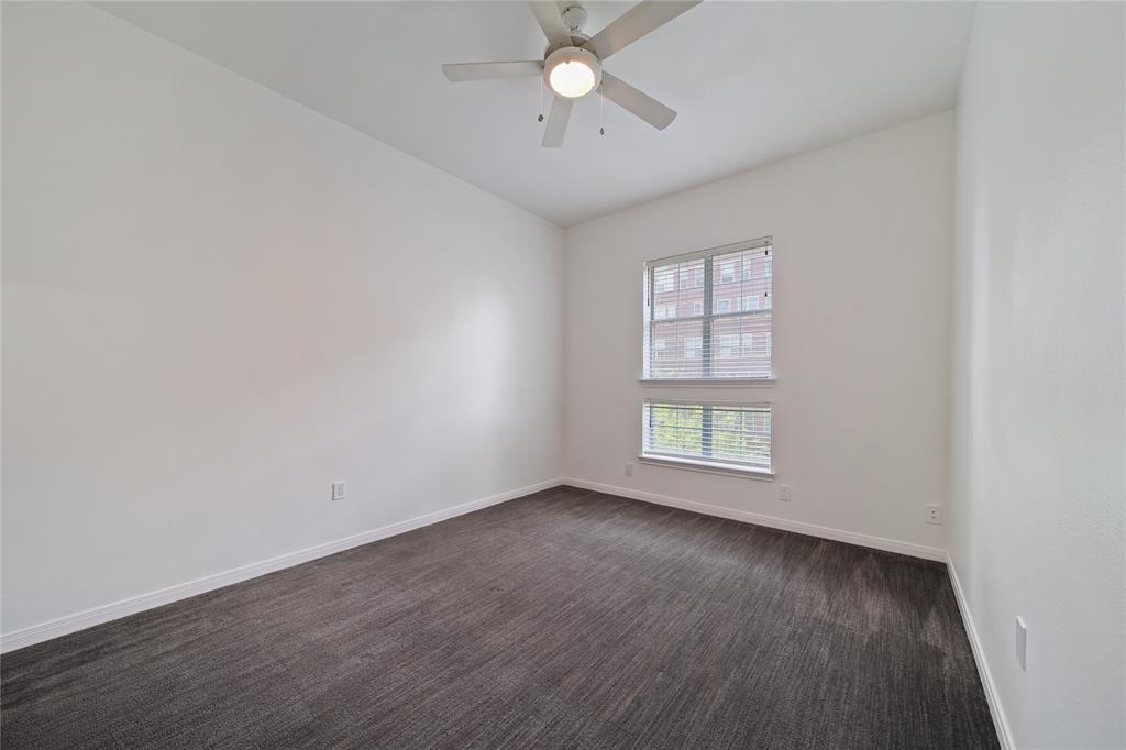 3225 Turtle Creek Boulevard, Unit 320 Dallas, TX 75219 - Photo 10 of 24 an empty room with wooden floor chandelier fan and windows