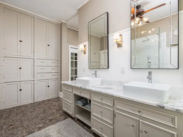 a spacious bedroom with a balcony a bed and a flat tv screen on dresser