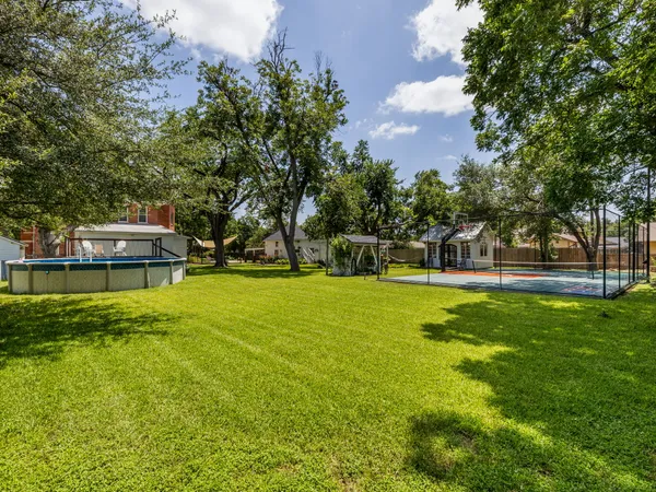 an aerial view of residential houses with outdoor space and trees all around