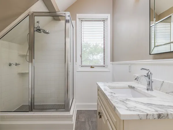 a bathroom with a granite countertop tub sink and mirror
