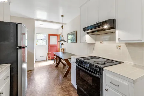 a kitchen with a refrigerator and a stove top oven
