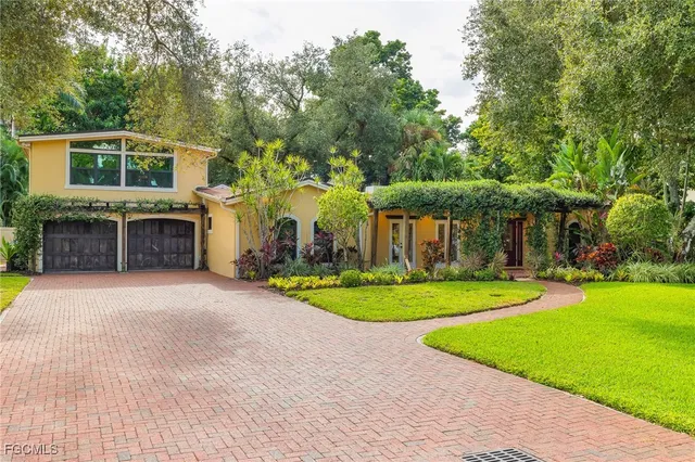 a front view of a house with a yard and trees