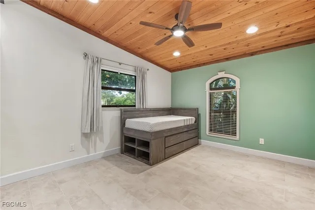 a spacious bedroom with a bed and a chandelier