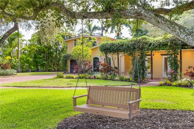 a view of a park with large trees and a barn in it