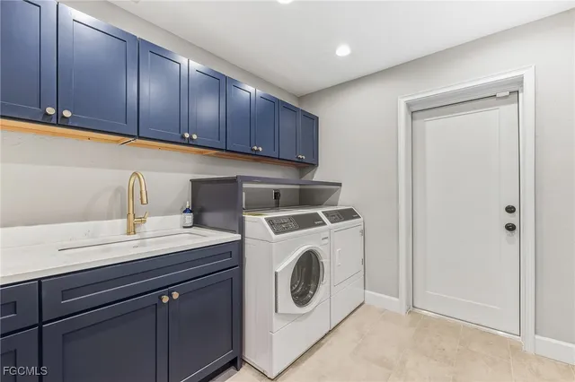 a utility room with sink dryer and washer