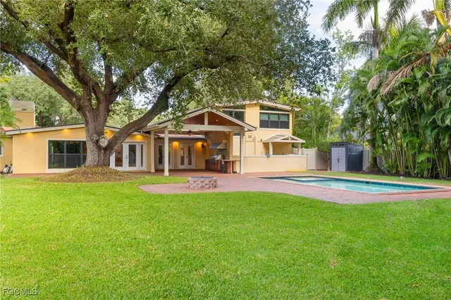 a front view of a house with a garden and trees