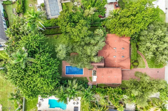 an aerial view of a house with a yard and trees