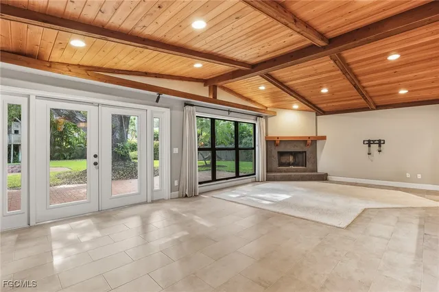 a view of an empty room with a fireplace and a ceiling fan