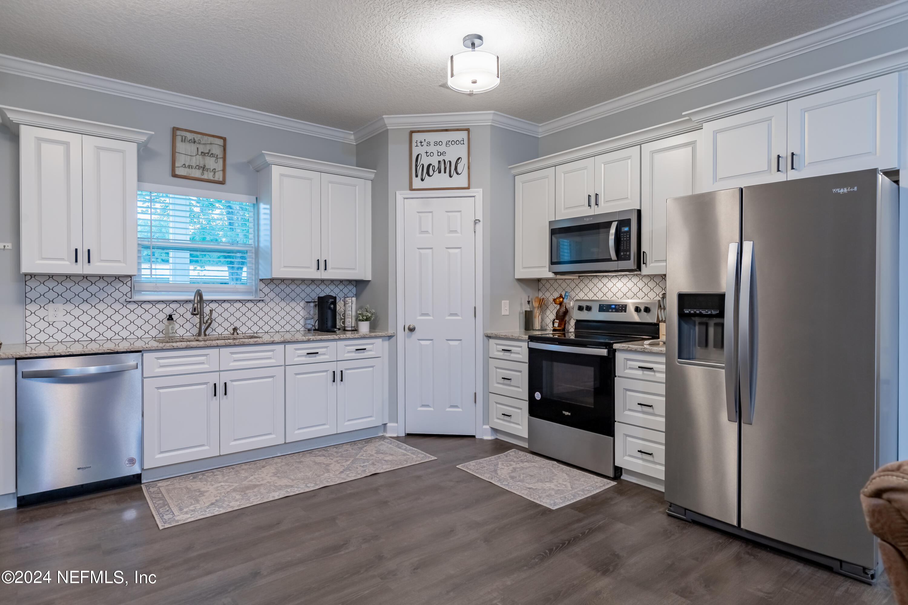 6477 Keith Griffis Circle Macclenny, FL 32063 - Photo 19 of 30 a kitchen with granite countertop white cabinets and stainless steel appliances