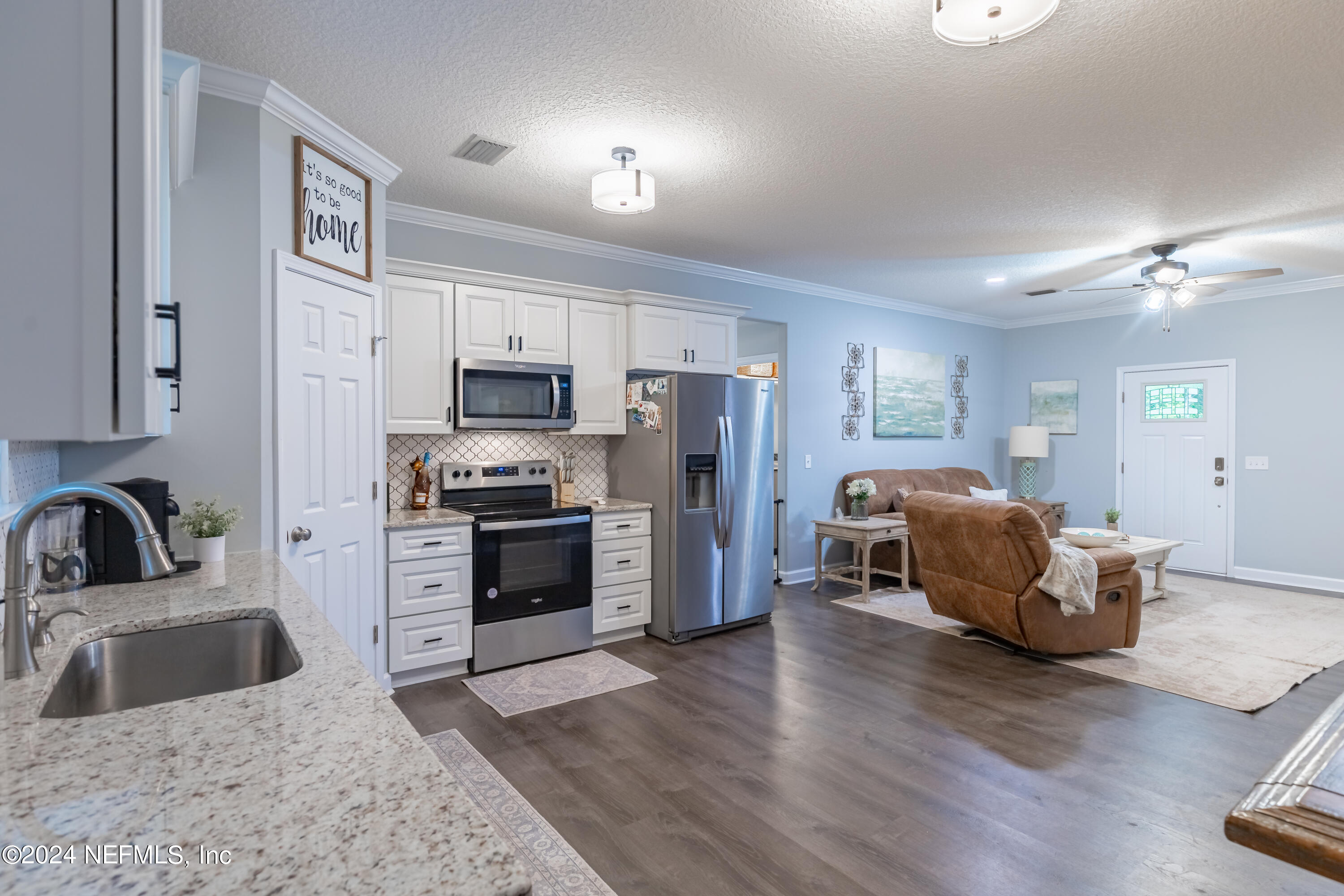 6477 Keith Griffis Circle Macclenny, FL 32063 - Photo 20 of 30 a kitchen with a refrigerator sink and cabinets