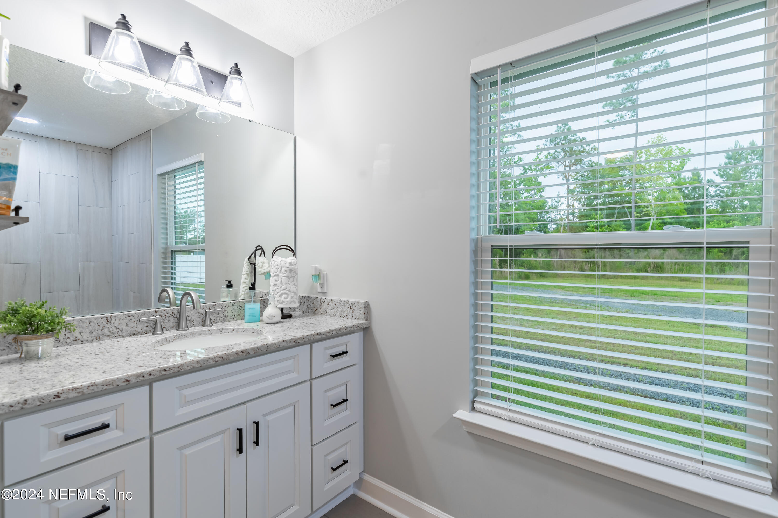 6477 Keith Griffis Circle Macclenny, FL 32063 - Photo 23 of 30 a bathroom with a sink and a mirror