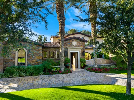 a front view of a house with a garden and plants