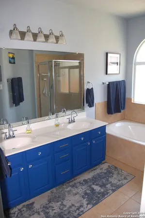 a bathroom with a tub double sink and mirror