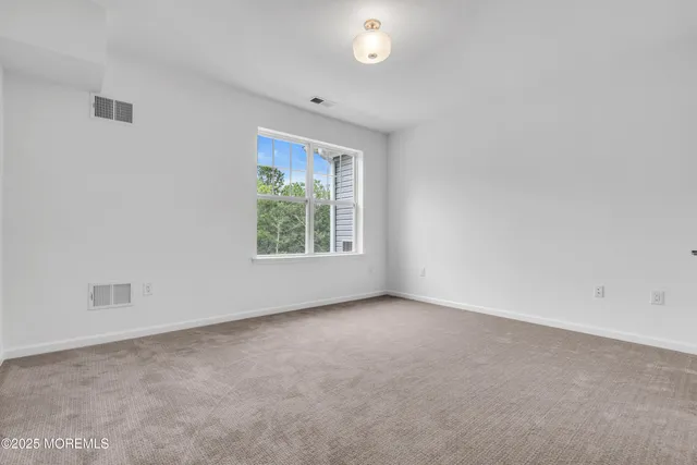 a living room with couches a fireplace and a dining table with garden view