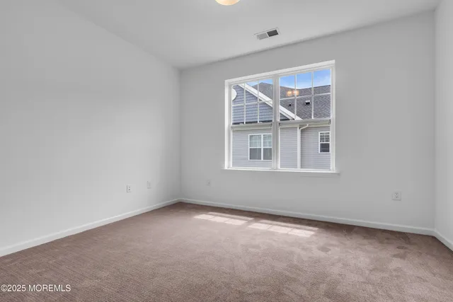 a view of a brick house with a big yard and large trees