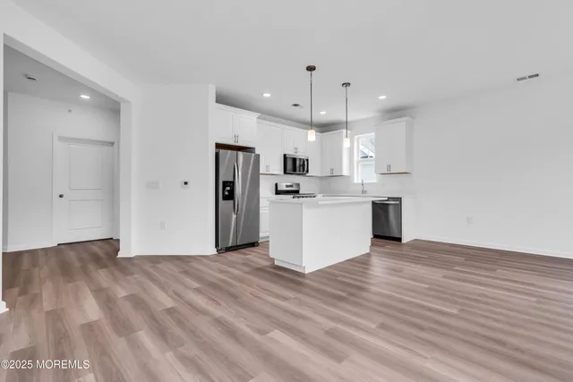 a view of a big room with wooden floor and windows