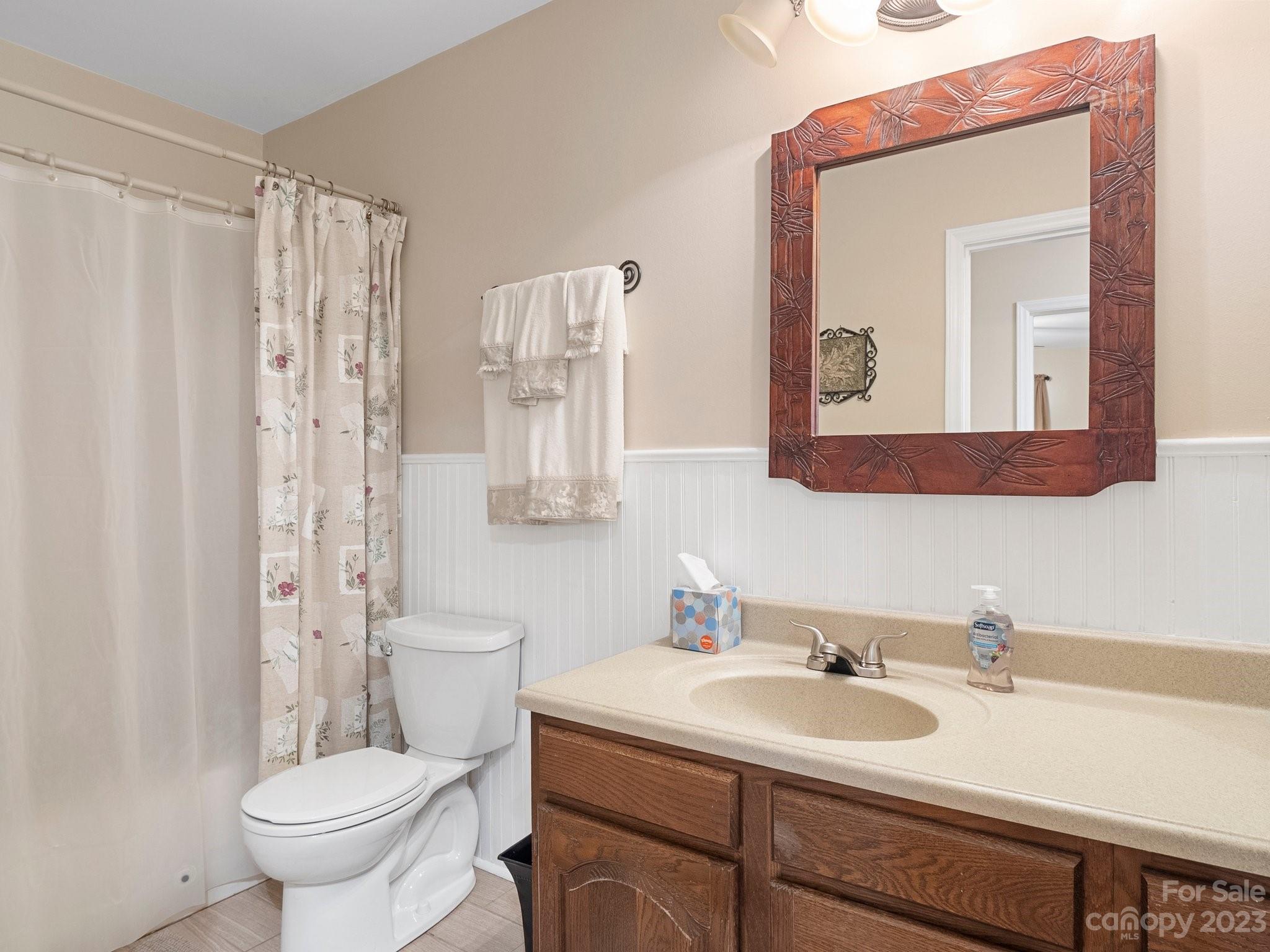 8211 Plott Road Charlotte, NC 28215 - Photo 19 of 38 a bathroom with a toilet a sink and a mirror