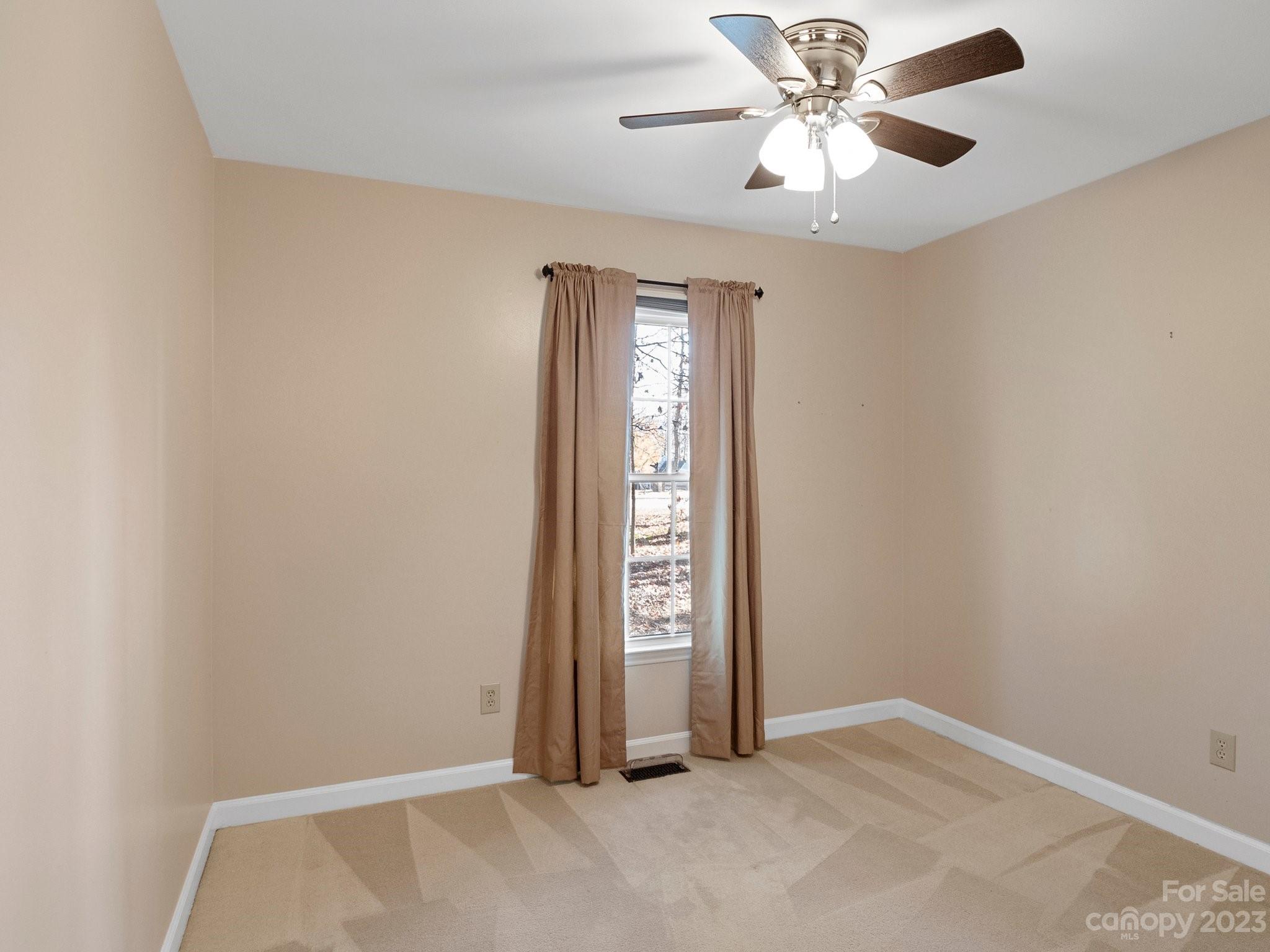 8211 Plott Road Charlotte, NC 28215 - Photo 21 of 38 an empty room with windows and fan