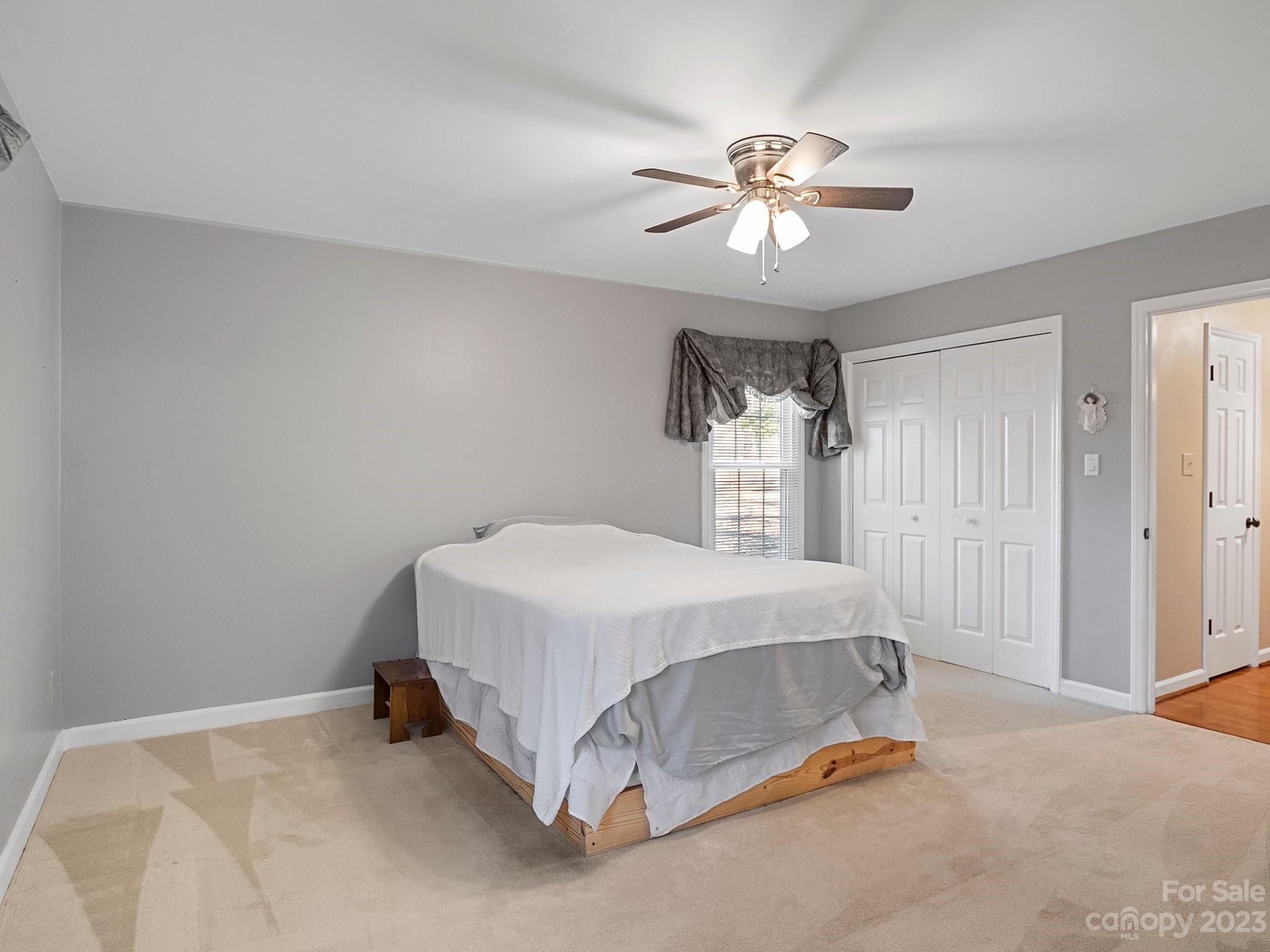 8211 Plott Road Charlotte, NC 28215 - Photo 23 of 38 a bedroom with a bed and a chandelier