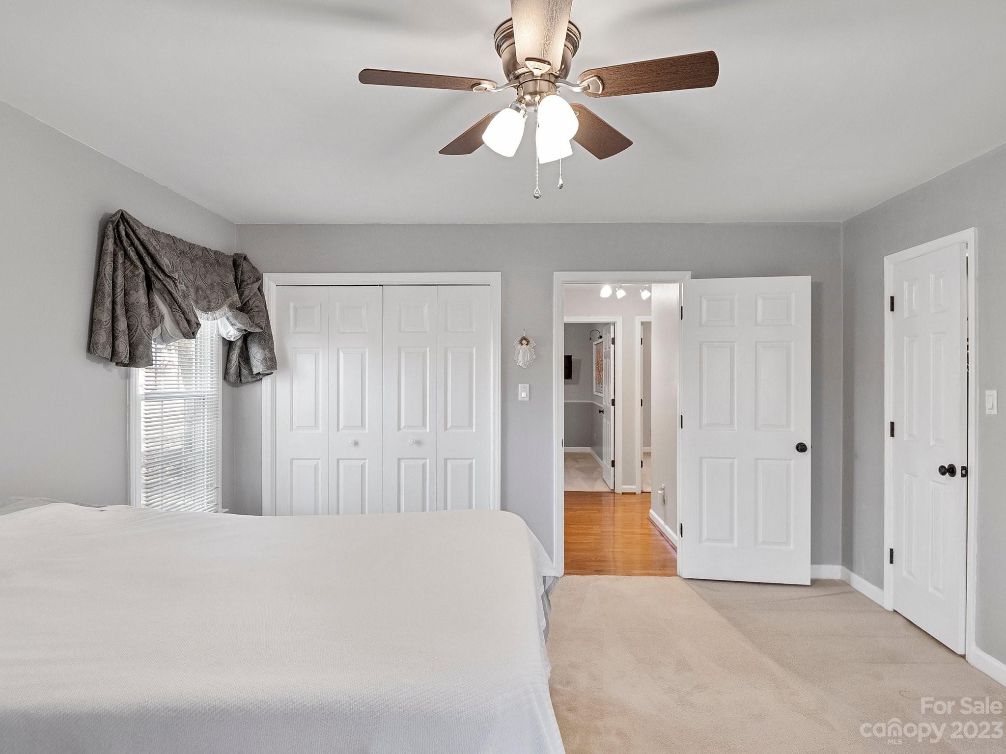 8211 Plott Road Charlotte, NC 28215 - Photo 24 of 38 a bedroom with a large bed and a chandelier