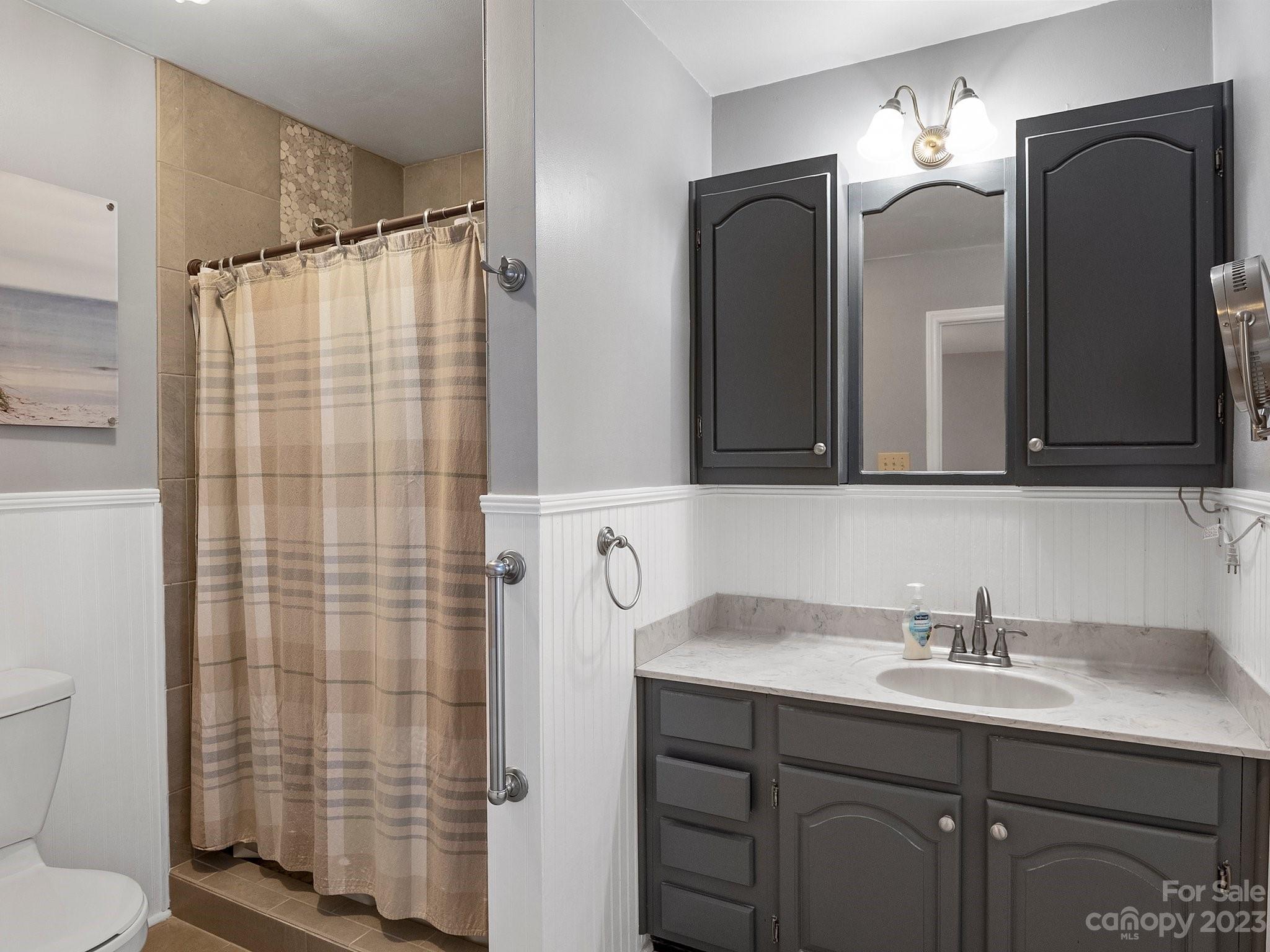 8211 Plott Road Charlotte, NC 28215 - Photo 25 of 38 a bathroom with a double vanity sink mirror and shower