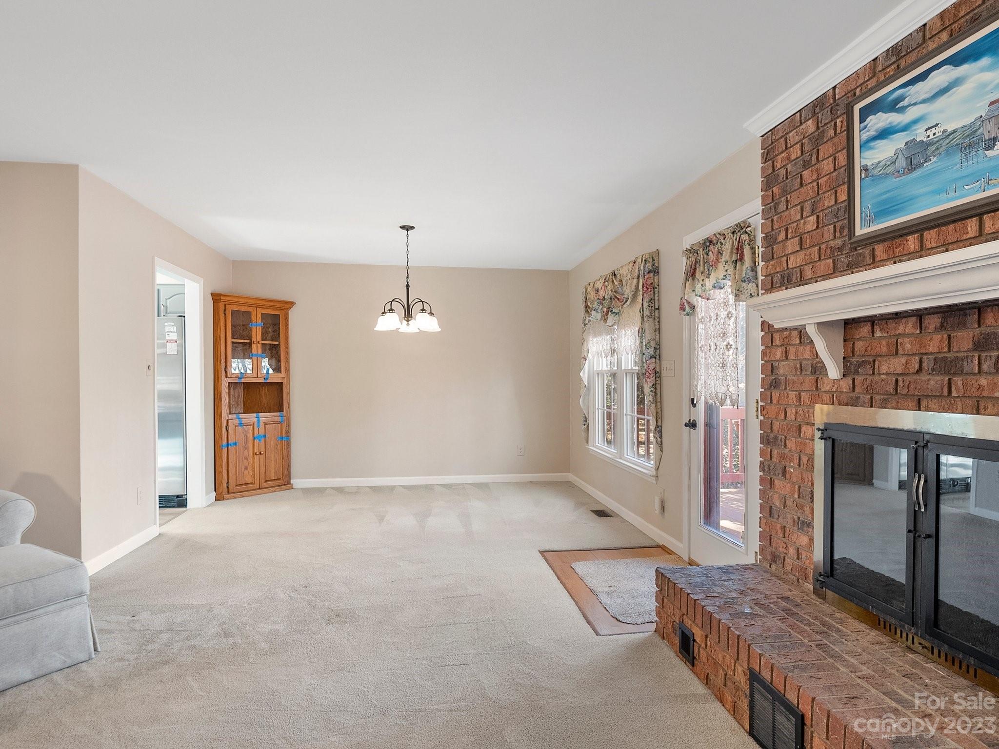 8211 Plott Road Charlotte, NC 28215 - Photo 10 of 38 a view of an empty room with a fireplace and a window