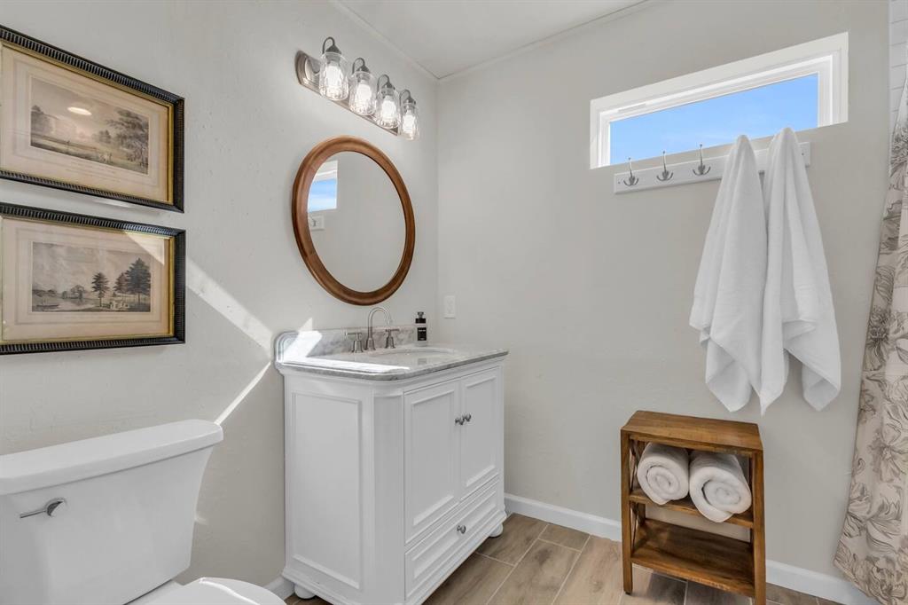 9780 North County Road Frisco, TX 75033 - Photo 27 of 36 a bathroom with a toilet a sink and a mirror