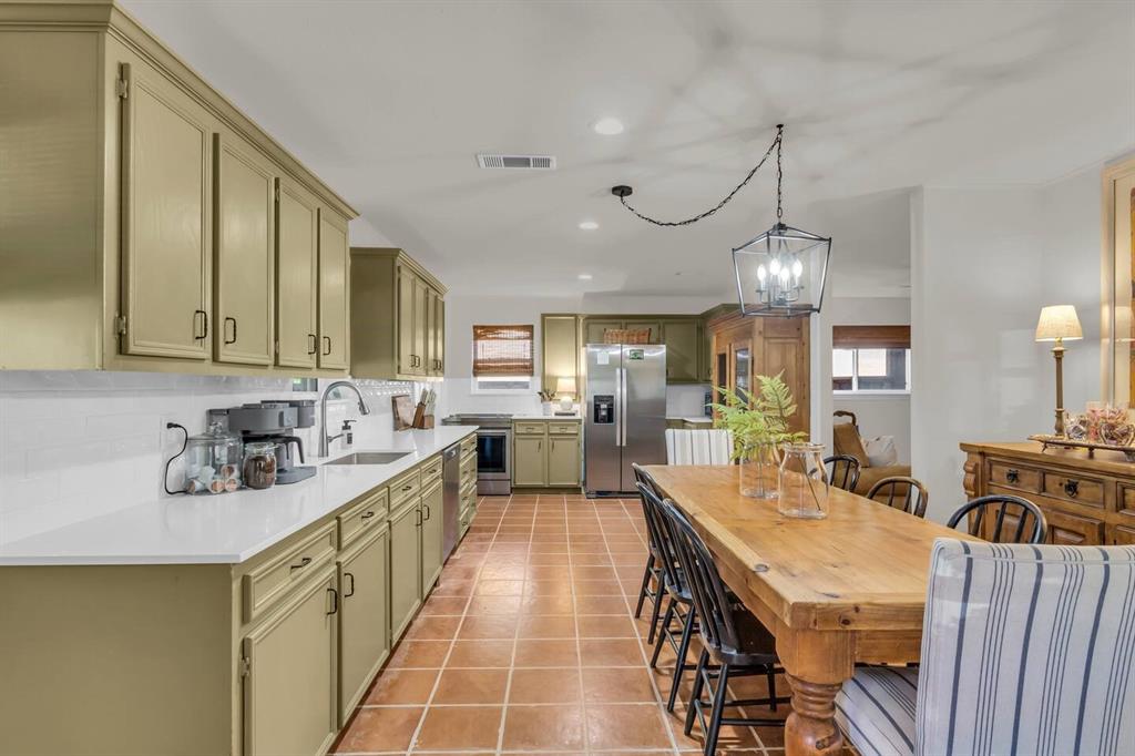 9780 North County Road Frisco, TX 75033 - Photo 10 of 36 a large kitchen with kitchen island stainless steel appliances a table chairs sink and cabinets