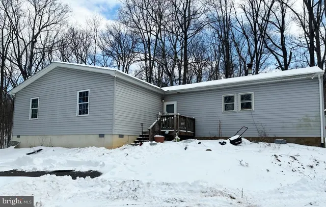 a view of a house with a yard covered in snow