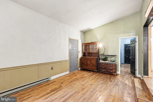an empty room with ceiling fan and windows