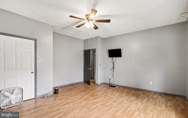 an empty room with a window and a ceiling fan