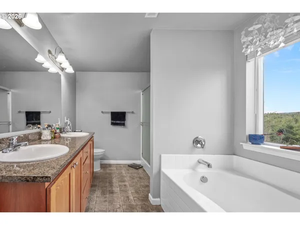 a bathroom with a sink double vanity granite tub shower and a mirror