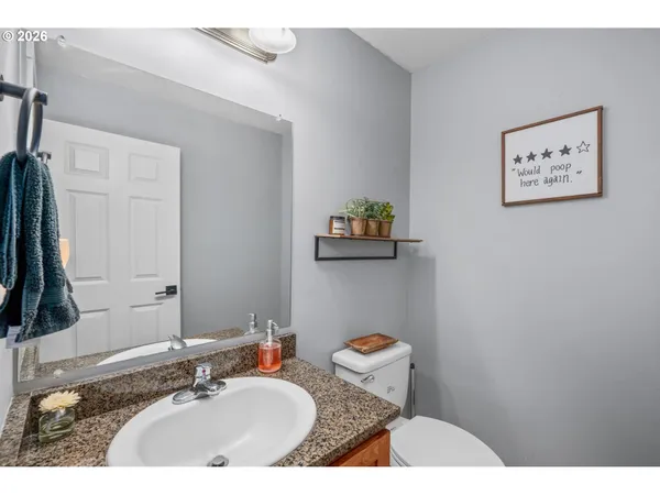 a bathroom with a sink vanity mirror and a toilet