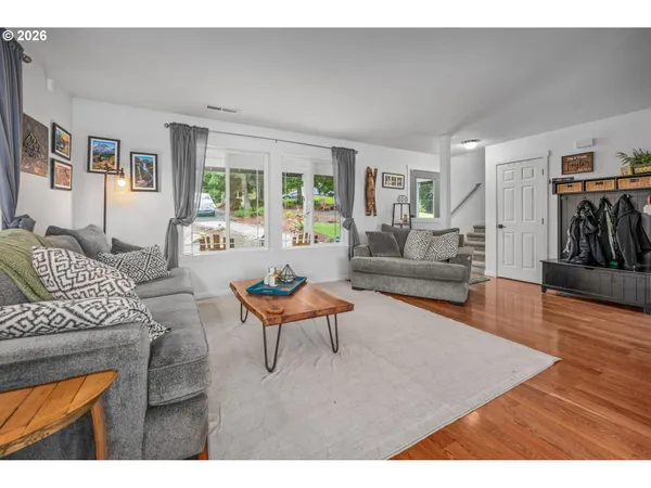 a living room with furniture and a wooden floor